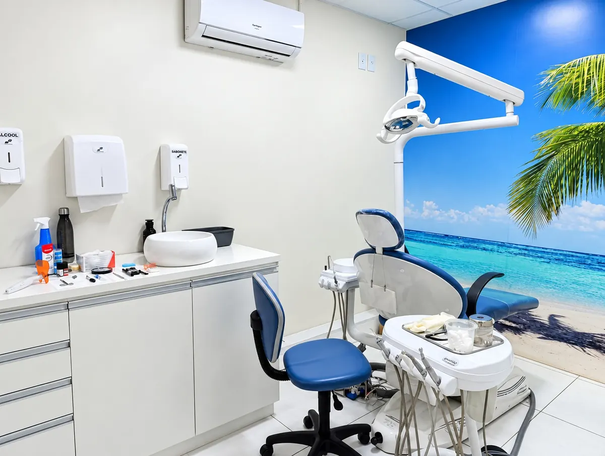 Consultório da RS ODONTO com painel de praia e cadeira azul